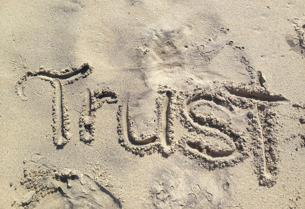 Im Sand steht Trust